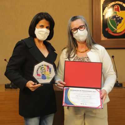 A Secretária Municipal de Educação, Marli Franco entrega o troféu e certificado a 1ª colocada da premiação: professora Stela Maris, representante do projeto